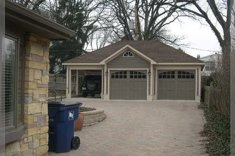 A two car garage with beige doors and a brown roof A two-car garage with beige doors and a brown roof