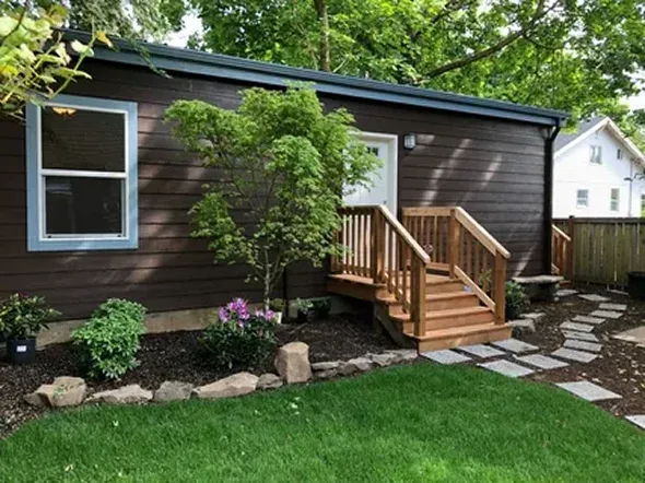 Brown house with wooden steps and landscaped garden Brown house with wooden steps and landscaped garden