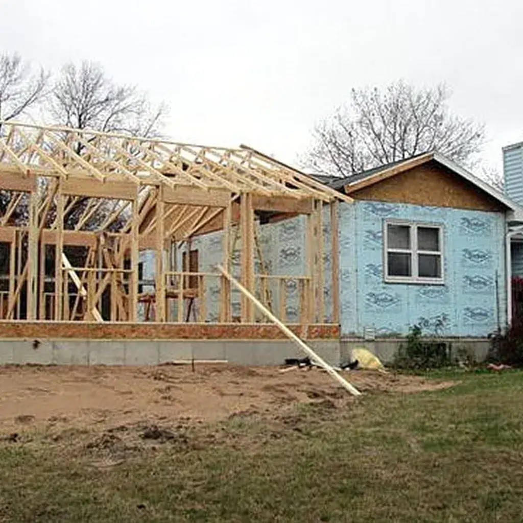 House under construction with wooden frame and blue insulation