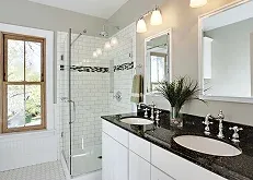 Modern bathroom featuring dual sinks, a glass shower