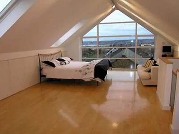 Spacious attic bedroom with large windows and hardwood floor Spacious attic bedroom with large windows and hardwood floor