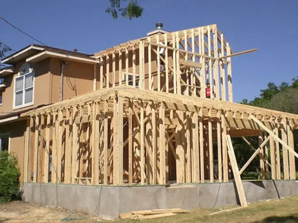 Wooden frame structure under construction, clear blue sky