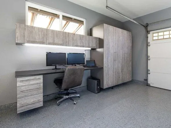 garage workspace featuring a gray desk with dual monitors garage workspace featuring a gray desk with dual monitors